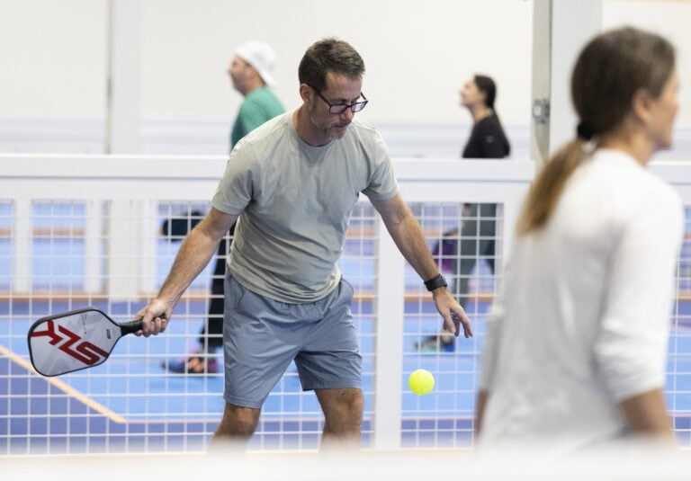 Man focusing on hitting the ball during an intense pickleball match