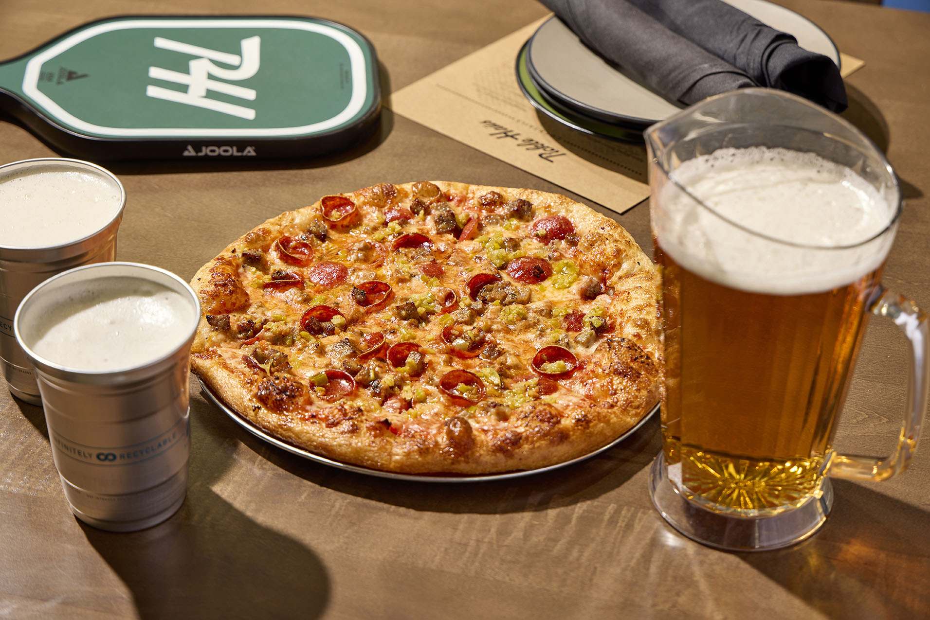 pizza and pitcher of beer on table